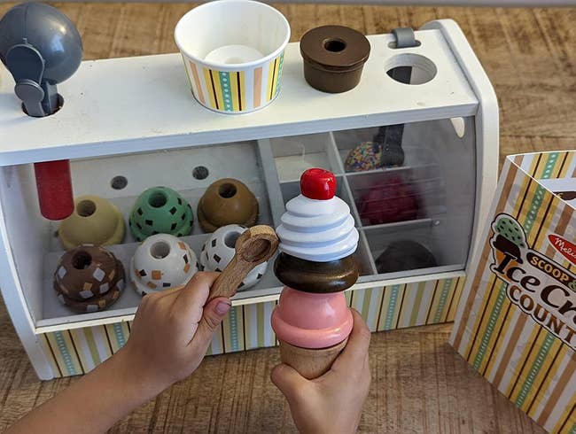 image of reviewer's child adding scoops of pretend ice cream to a pretend cone