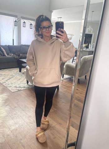 reviewer wearing oversized cream color hoodie 