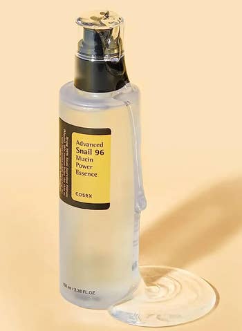 COSRX Advanced Snail 96 Mucin Power Essence successful  a wide   vessel  with achromatic  pump, with merchandise  spilling astatine  the base