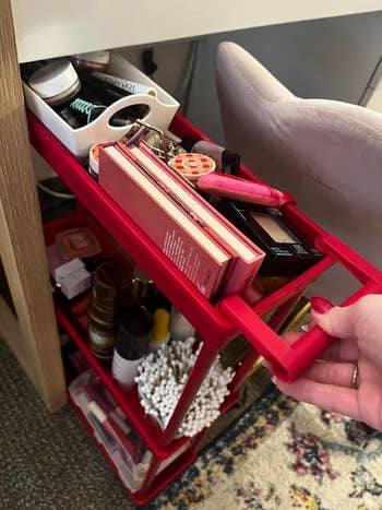 A red rolling cart filled with various beauty products