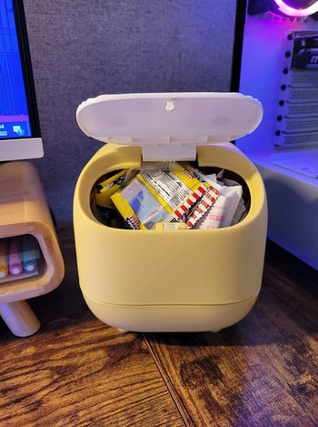 the mini trash can open in yellow with snacks inside
