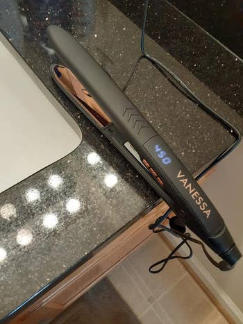 Reviewer image of black and gold straightener with digital display on counter