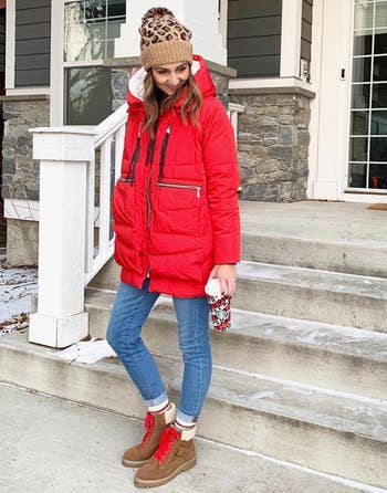 a reviewer wearing the coat in red