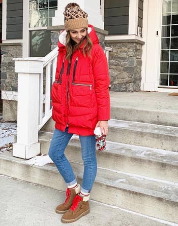 a reviewer wearing the coat in red