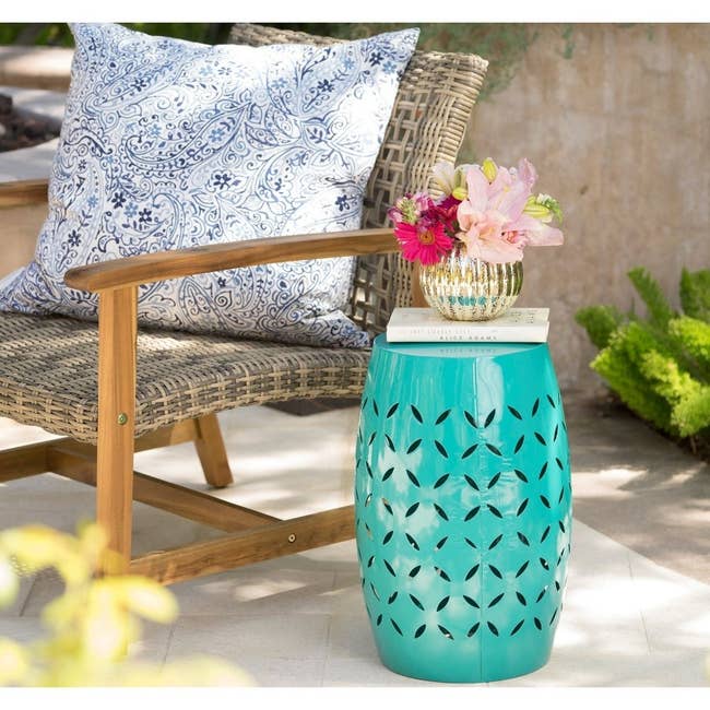a teal side table outside next to a patio chair