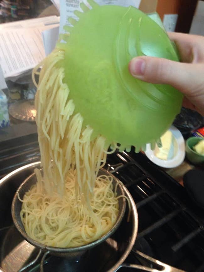 reviewer using the green server like a mitt, grabbing pasta from a pot