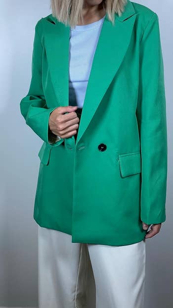 a reviewer wearing the blazer in green 