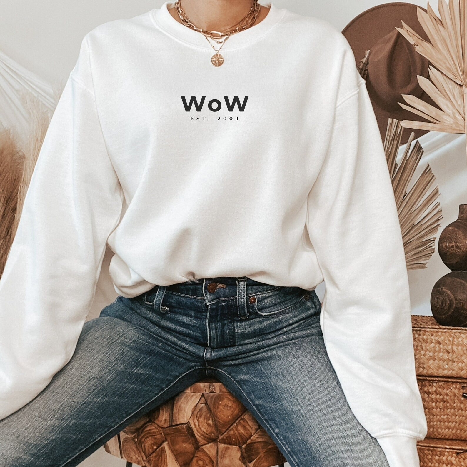 a model wearing a white crewneck that says 