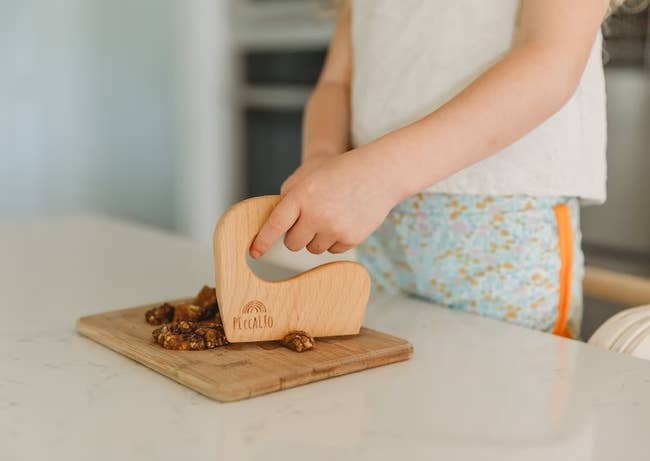 child using mini wood cutter to chop nuts