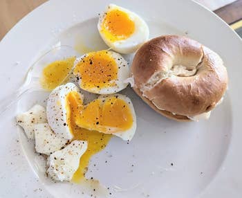 a reviewer's perfectly cooked hard boiled eggs next to a bagel