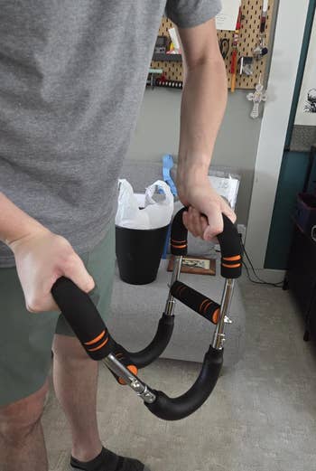 Person holding an ab roller with brushed  grips, demonstrating fittingness  instrumentality  usage  successful  a location  setting