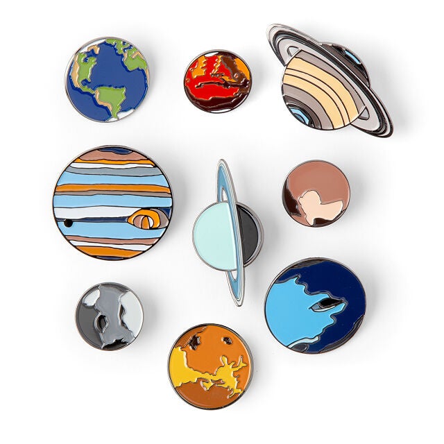 enamel pins all representing the eight planets in the Milky Way solar system.