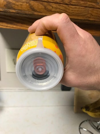 reviewer holding covered can horizontally to show leak proof