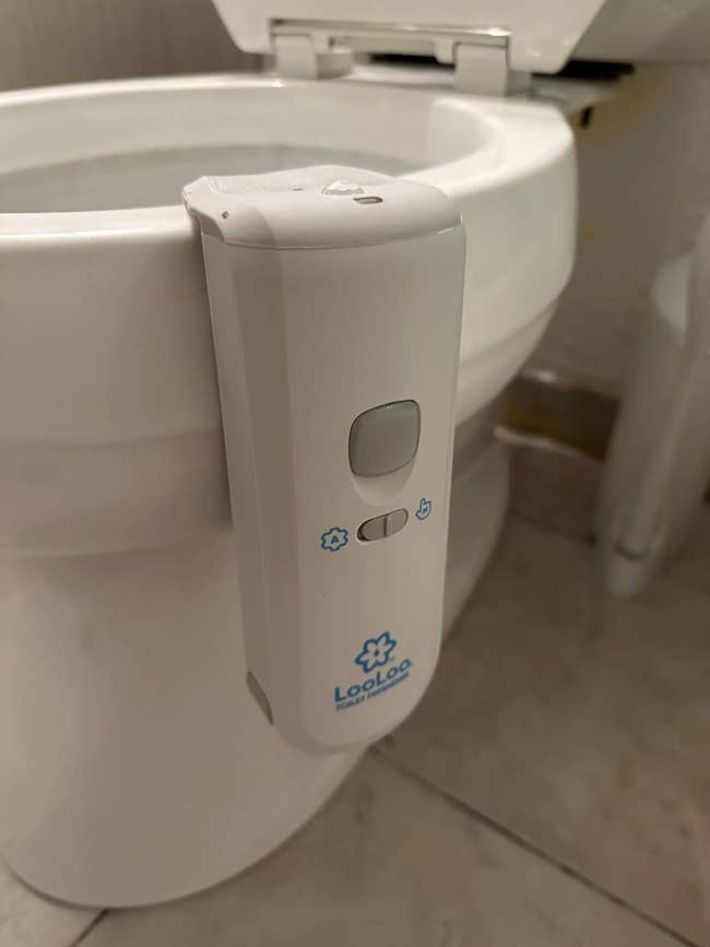 Automatic toilet bowl cleaner mounted on the side of a toilet