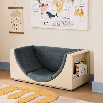 Children's speechmaking nook with a comfy cushioned spot and built-in bookshelf. A satellite representation decorates the partition above. Ideal for kids' spaces