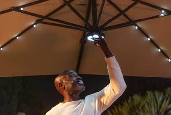 a model adjusting the lighting in the umbrella