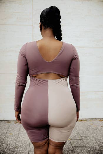 the same model showing the back of the bodysuit and how it has a cut out in the middle