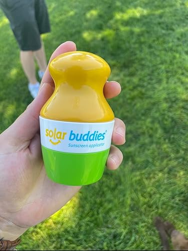 A manus  holds a Solar Buddies sunscreen applicator successful  a parkland  setting