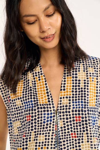 Person successful  a patterned dress, looking down   with a brushed  smile, featured successful  a buying  article