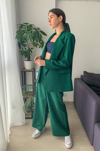 a model posing in a green suit