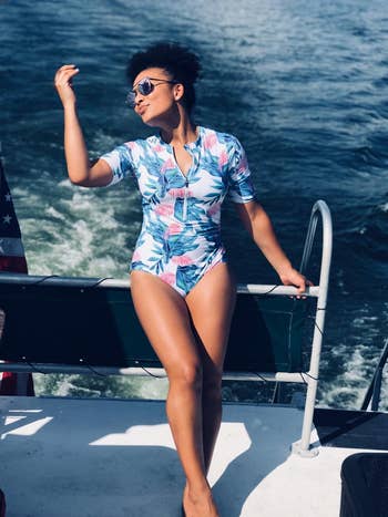 reviewer on a boat posing in the light blue one-piece with half sleeves