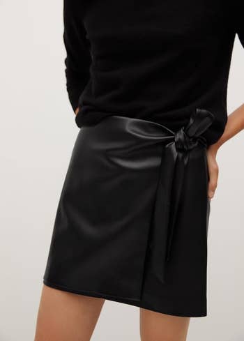 front view of a model wearing the knotted mini skirt