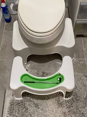 a reviewer's putting toilet stool in front of a toilet with traditional squatty potty