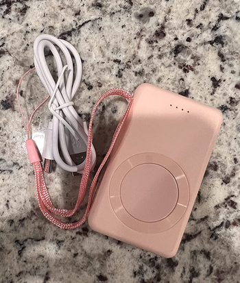A pink rectangular charger with an included wire and lanyard 
