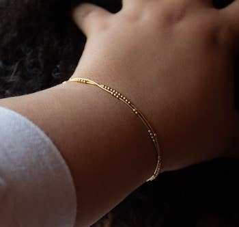 Model wearing the gold bracelet