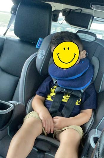 reviewer image of a child sleeping in a car with the neck pillow on