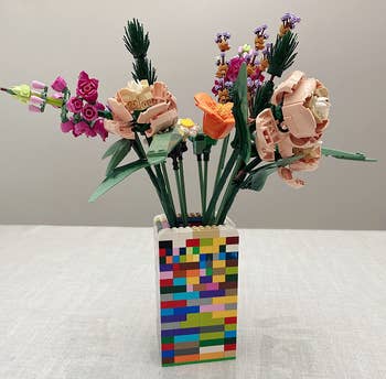 the set of lego flowers inside a lego-shaped vase