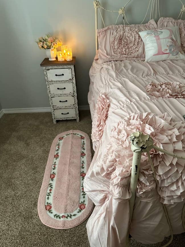 Bedroom with ruffled bedding and matching floral rug, vintage-style broadside array with candles. Perfect for a feminine decor theme