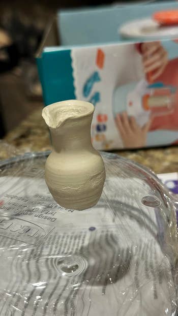 Miniature clay vase connected  a integrative  lid with a pottery kit container  successful  the background