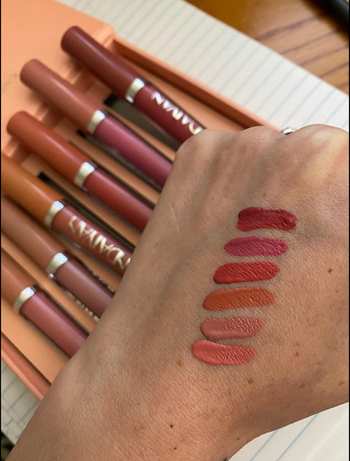 Reviewer wearing all six shades of pink and red matte on their hand 
