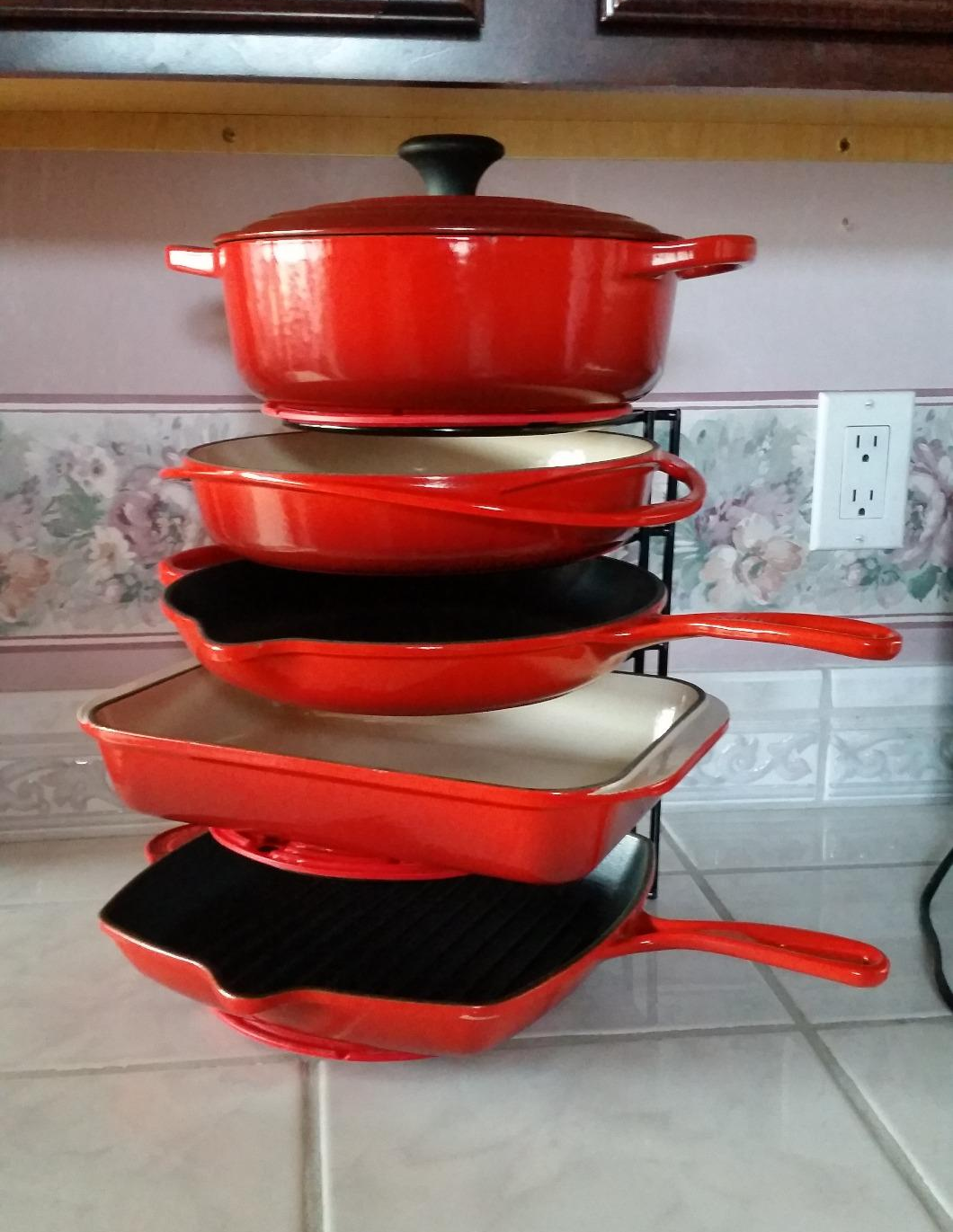 five pieces of red Le Creuset cast iron on this vertical organizer