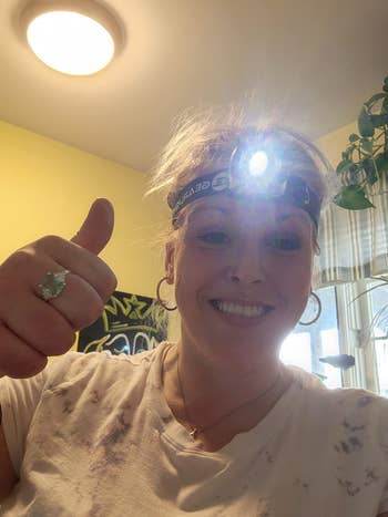 reviewer wearing the head lamp that has been turned on