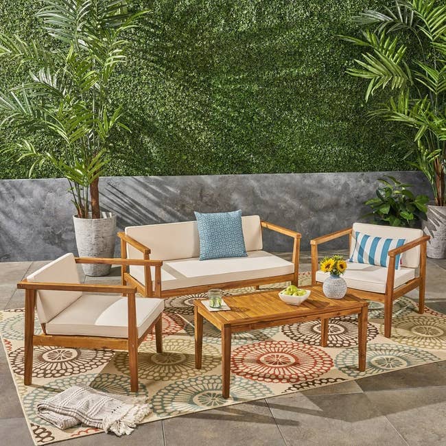 Outdoor furniture set with sofa, chairs, table, and decorative cushions on a patio