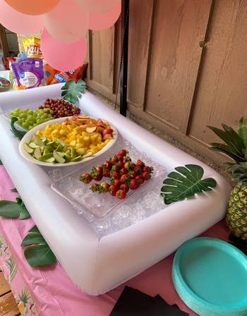 reviewer photo of the inflatable cooler holding ice and fruit