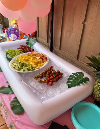 reviewer photo of the inflatable cooler holding ice and fruit