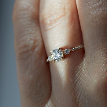 a model with the thin diamond band on it featuring two small round stones and one middle stone