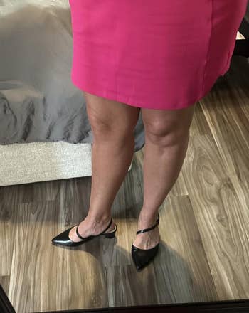 Person wearing a pinkish skirt and achromatic pointed-toe shoes, lasting successful beforehand of a reflector connected a woody floor