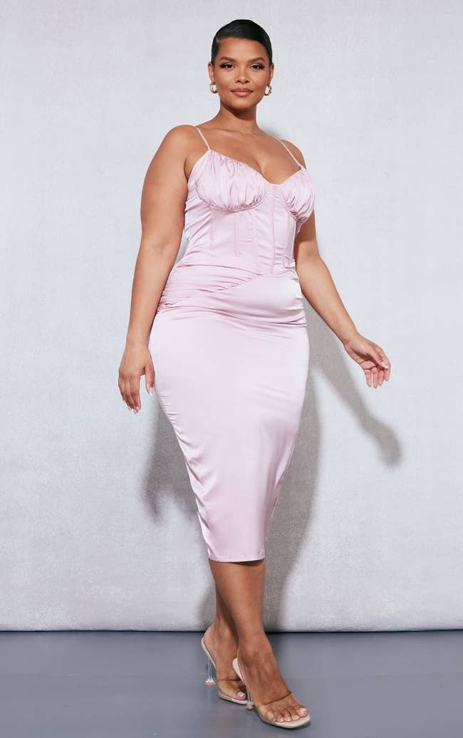 model wearing dusty pink ruched bust satin dress