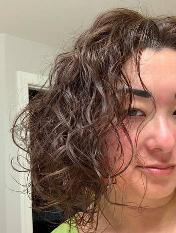 reviewer's curly hair thanks to the blow dryer