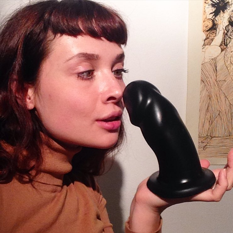 Woman with large black dildo in hand
