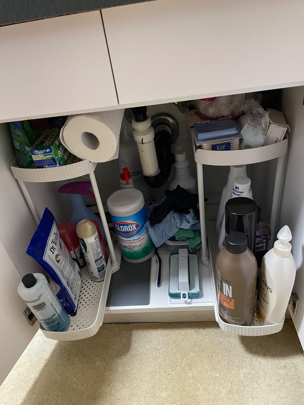 Organized under-sink retention  with cleaning supplies, toiletries, and insubstantial  towels