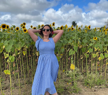 another reviewer wearing the dress in a sunflower field with white oxfords