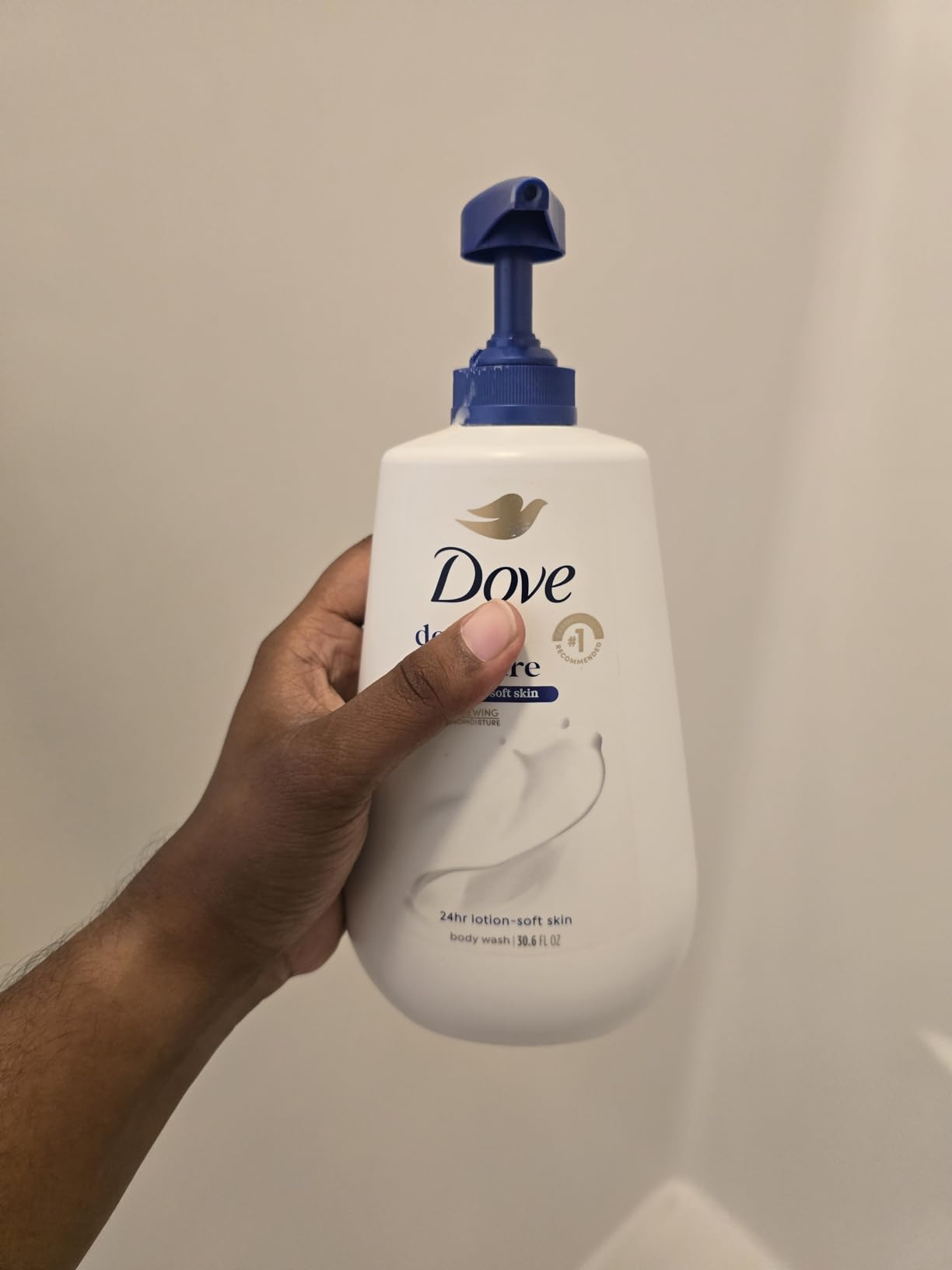 Hand holding Dove Deep Moisture assemblage  lavation  bottle