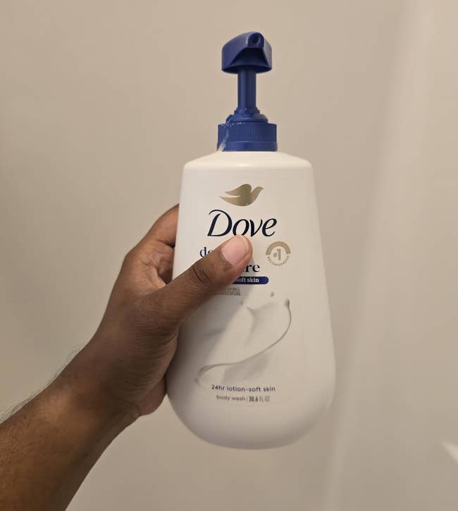 Hand holding Dove Deep Moisture assemblage lavation bottle