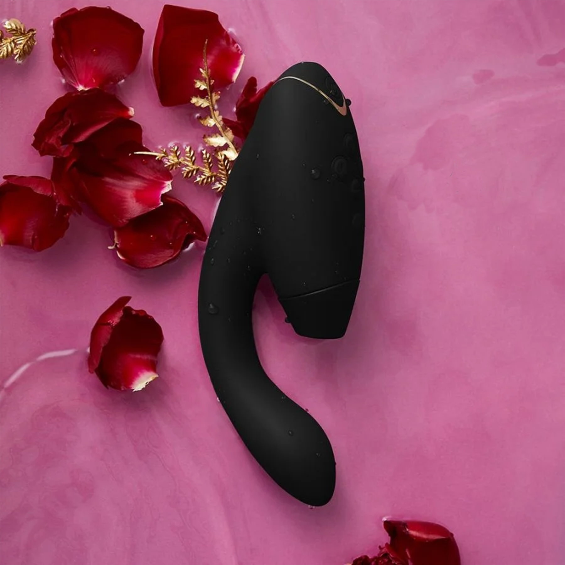 Black dual-stimulation sex toy next to rose petals
