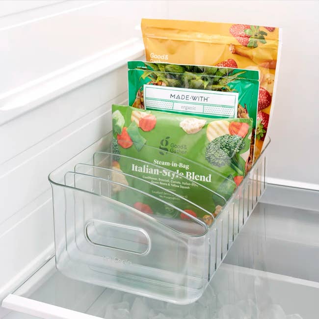 Clear organizer in fridge holding assorted frozen vegetable bags